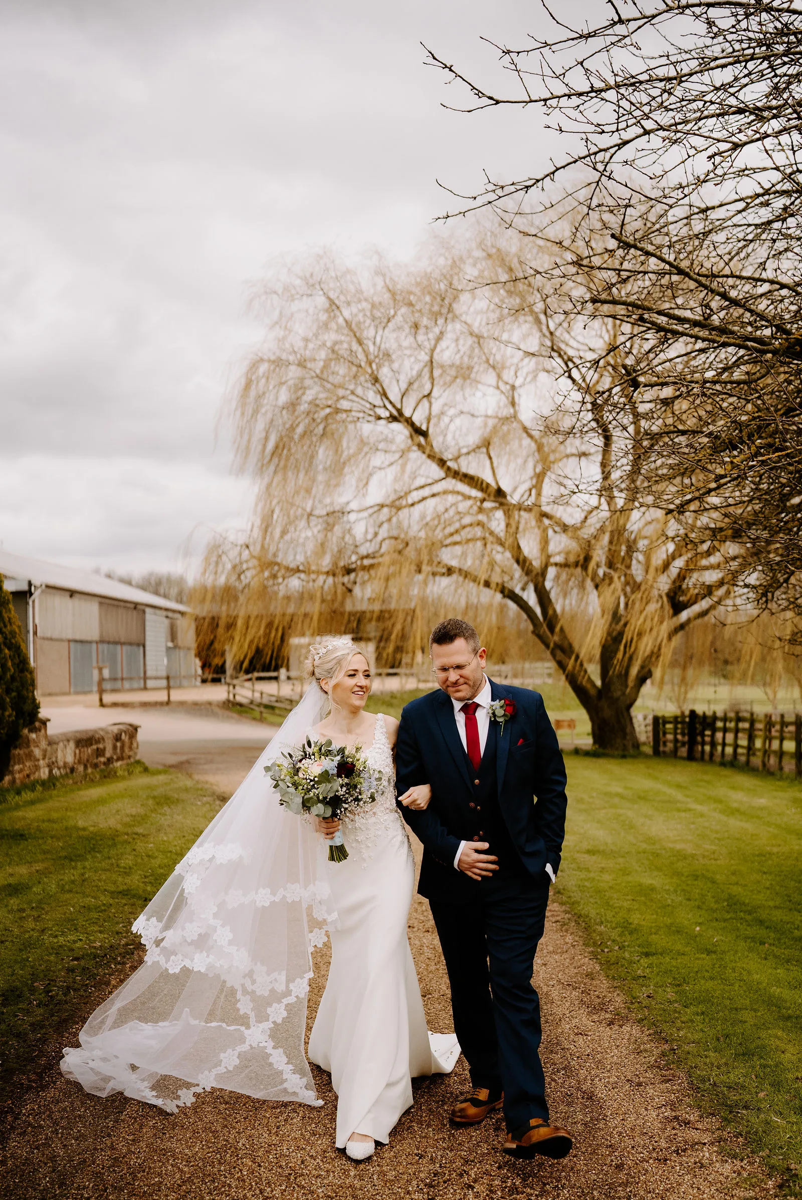 Bryan and Faye embracing in the rustic timber barn at Crockwell Farm in Eydon