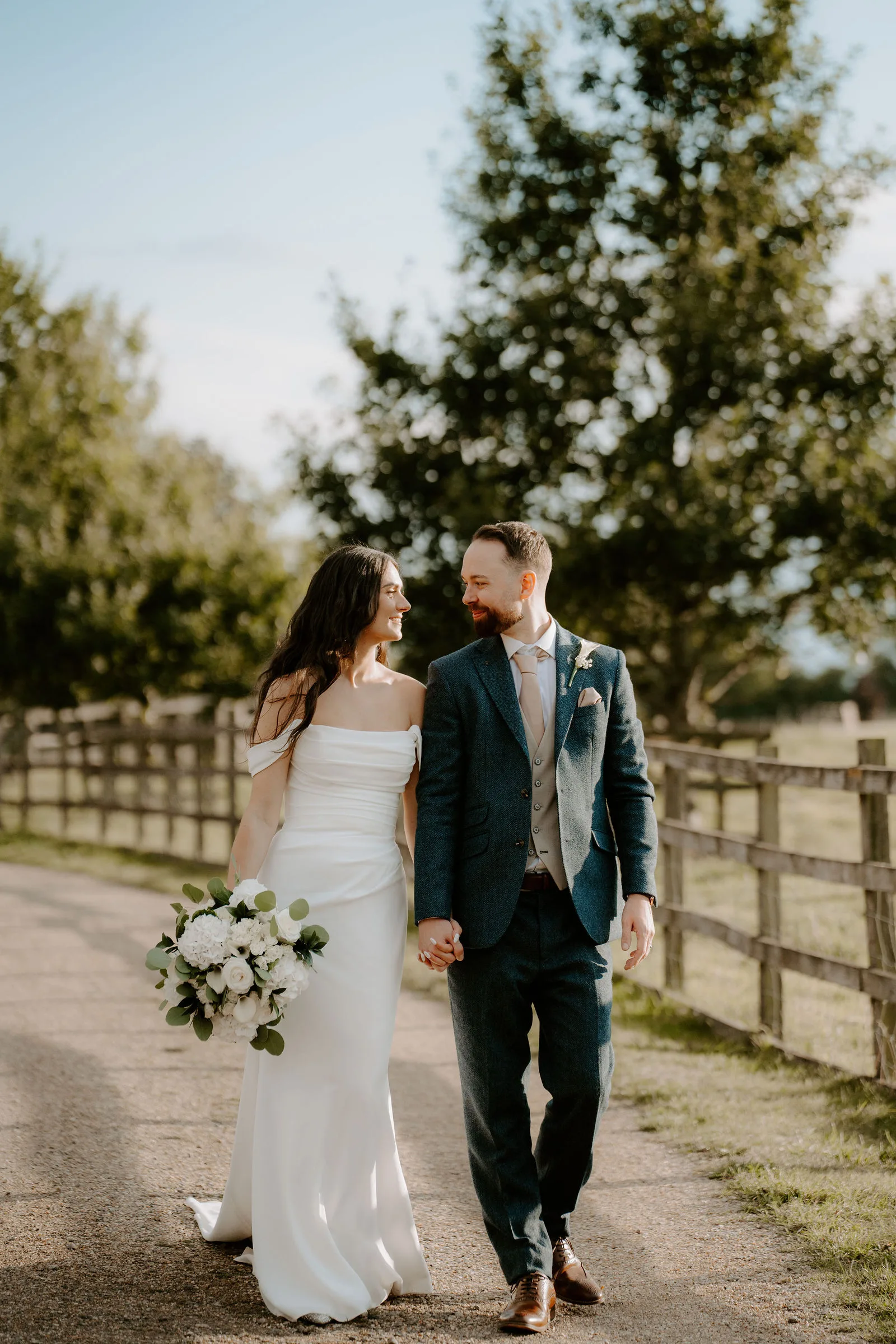 Confetti shower over Charlie and Faye as they step into the sunny courtyard at Dodford Manor