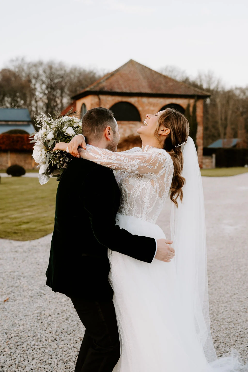Hayley and Martin embracing outside Hazel Gap Barn