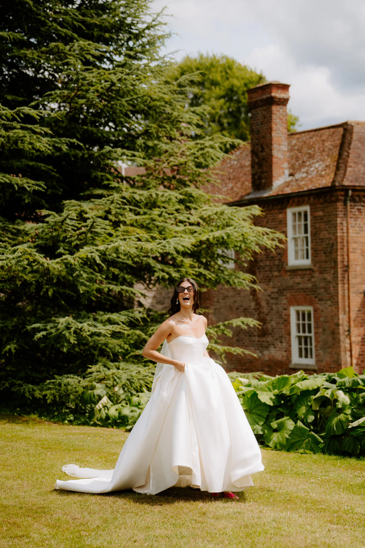 Bride smiling in the garden outside a country house wedding venue.