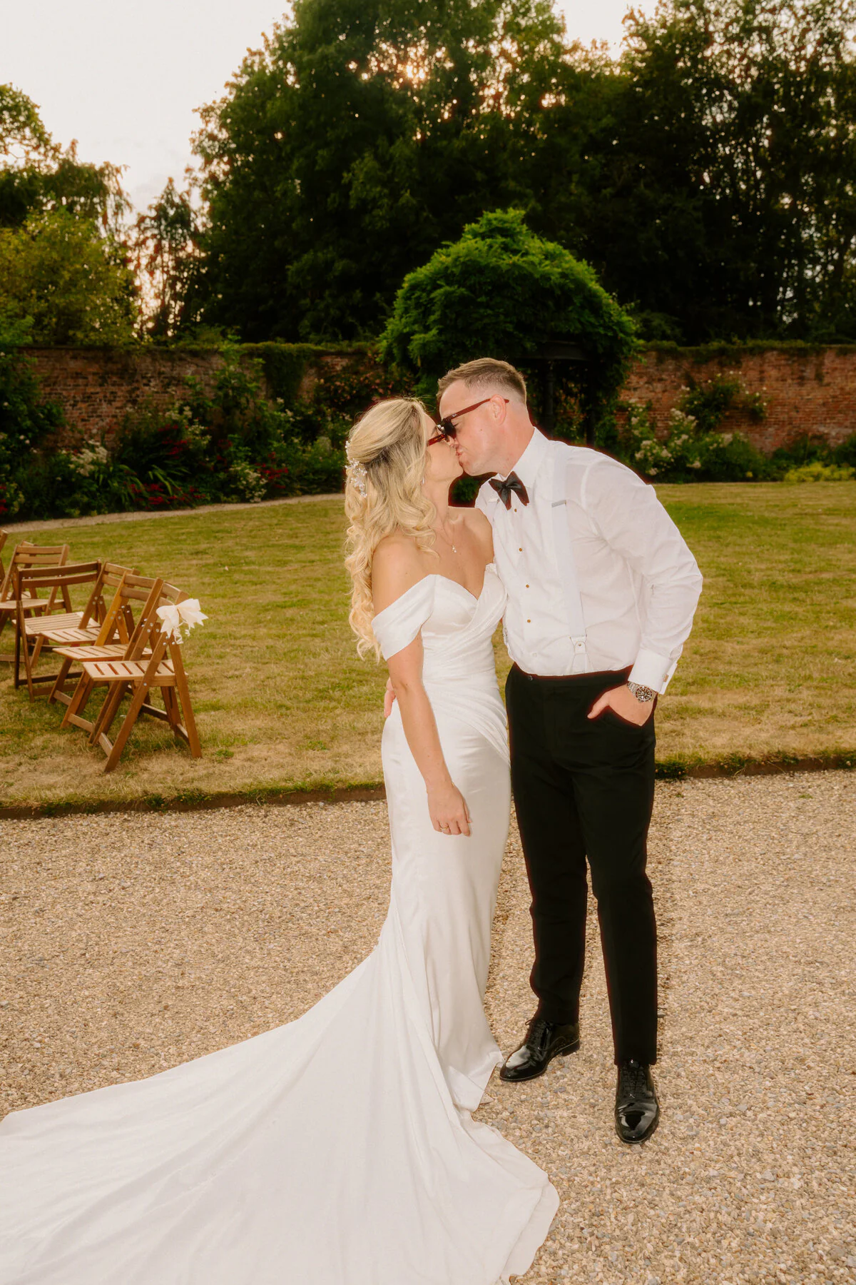 Newlyweds sharing a kiss in the garden during relaxed wedding photography.