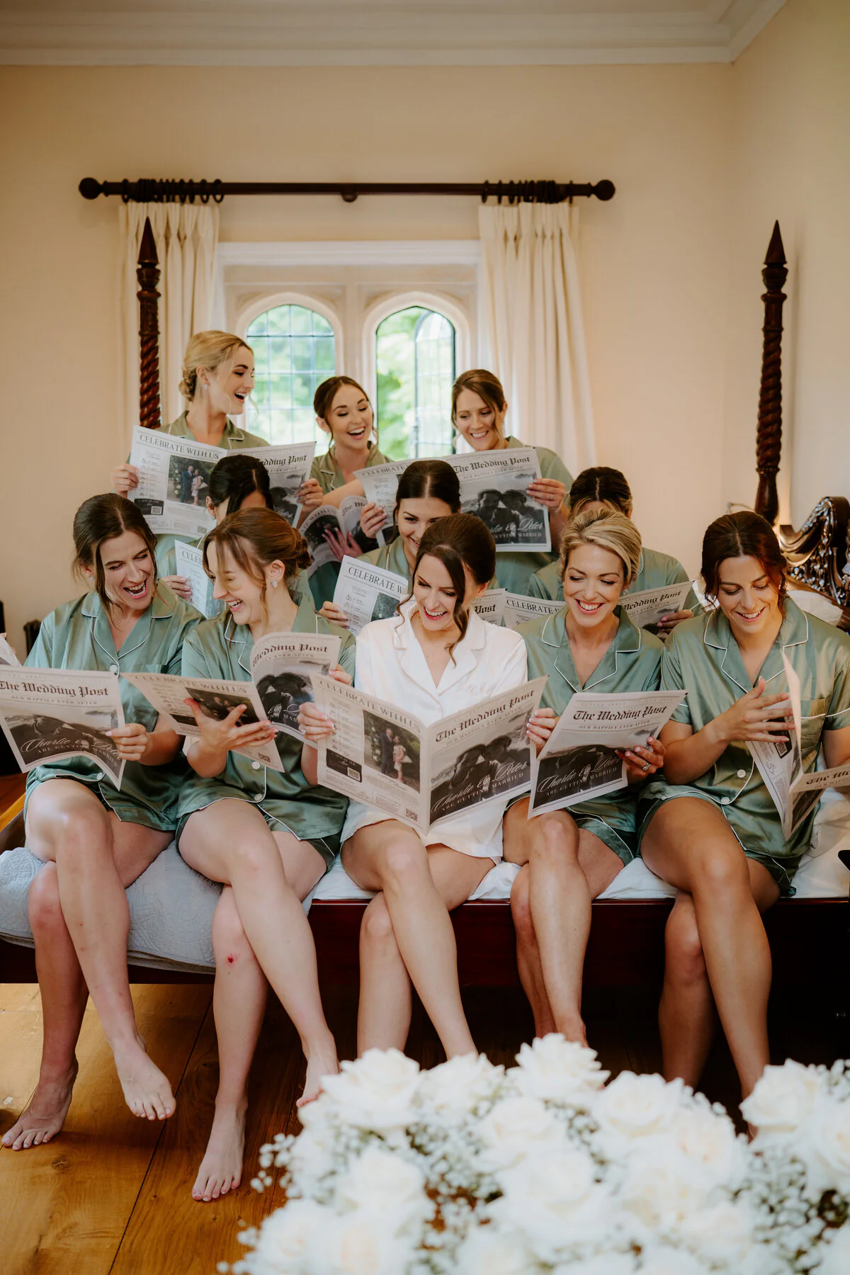 Bride and bridesmaids laughing together while getting ready on the wedding morning.