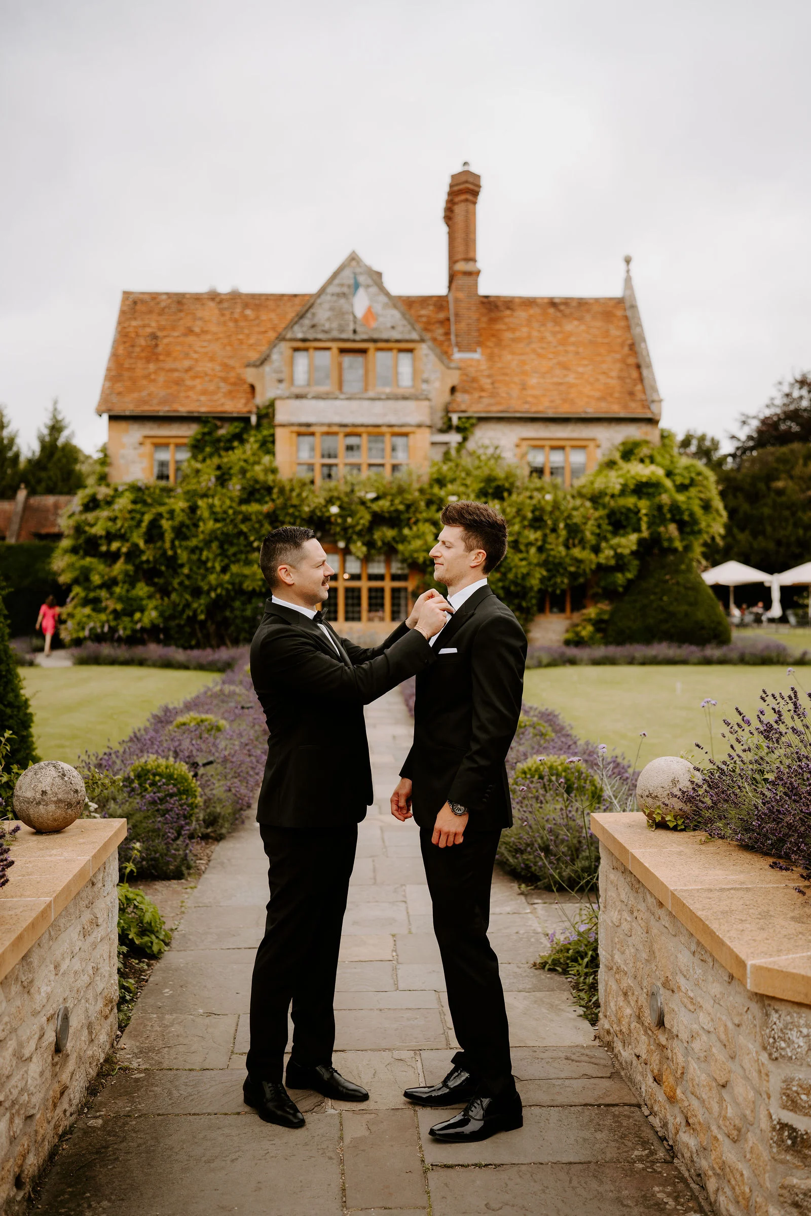George and Eden laughing together during drinks on the garden terrace at Le Manoir aux Quat'Saisons