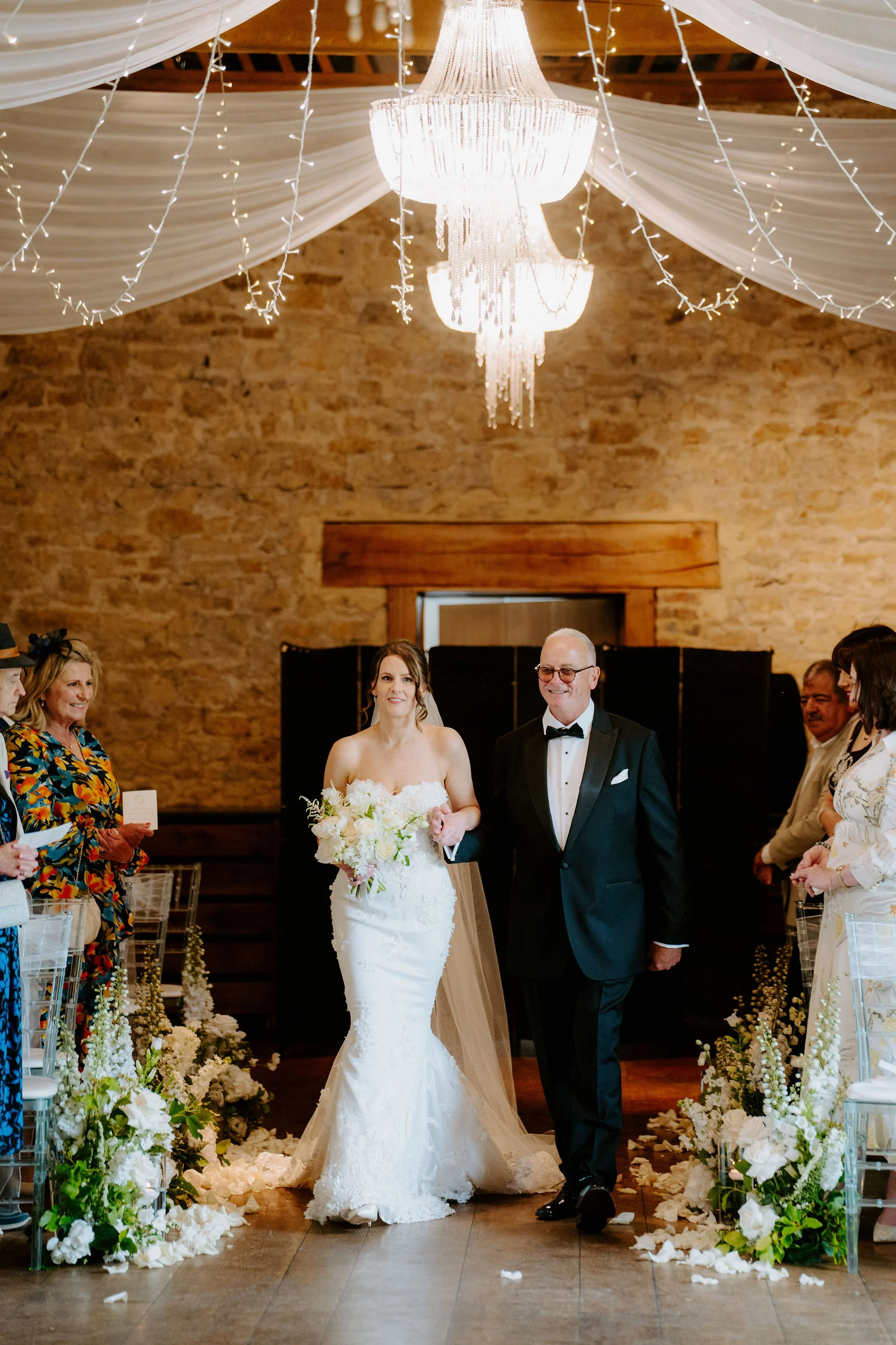 Confetti shower over Charlie and Peter as they exit the Monks' Refectory into the sunshine at Notley Abbey
