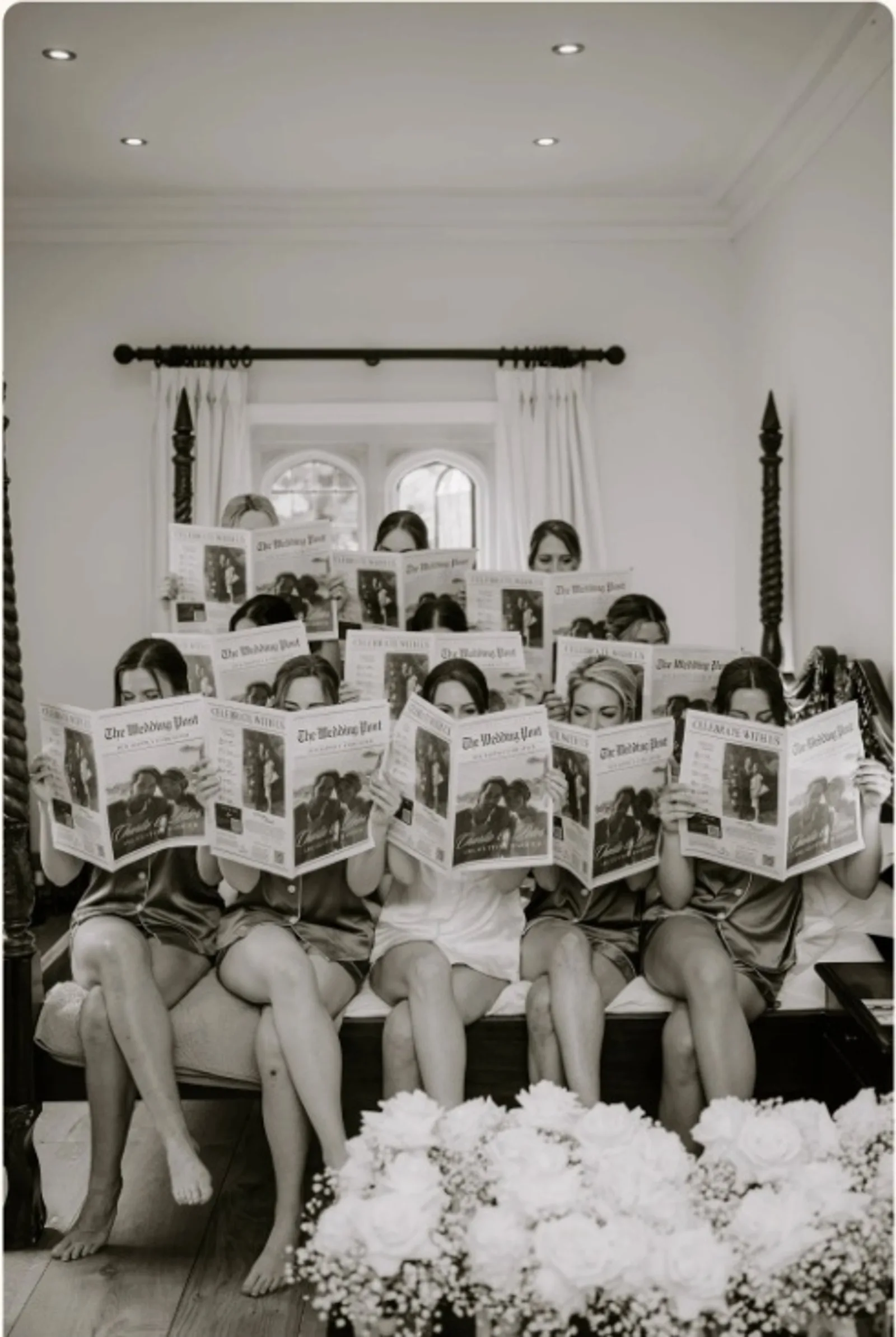 Bridesmaids reading The Wedding Post newspaper during morning preparations at Notley Abbey