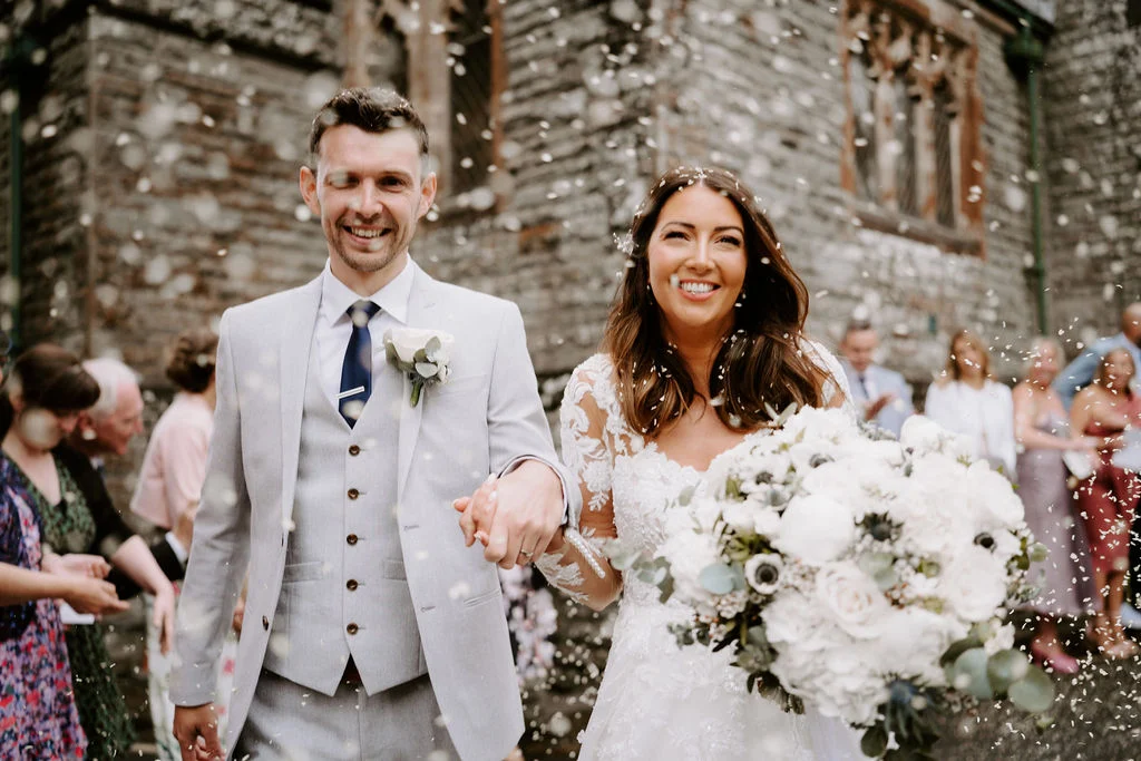 Jenny and Neil smiling outside their church after the ceremony