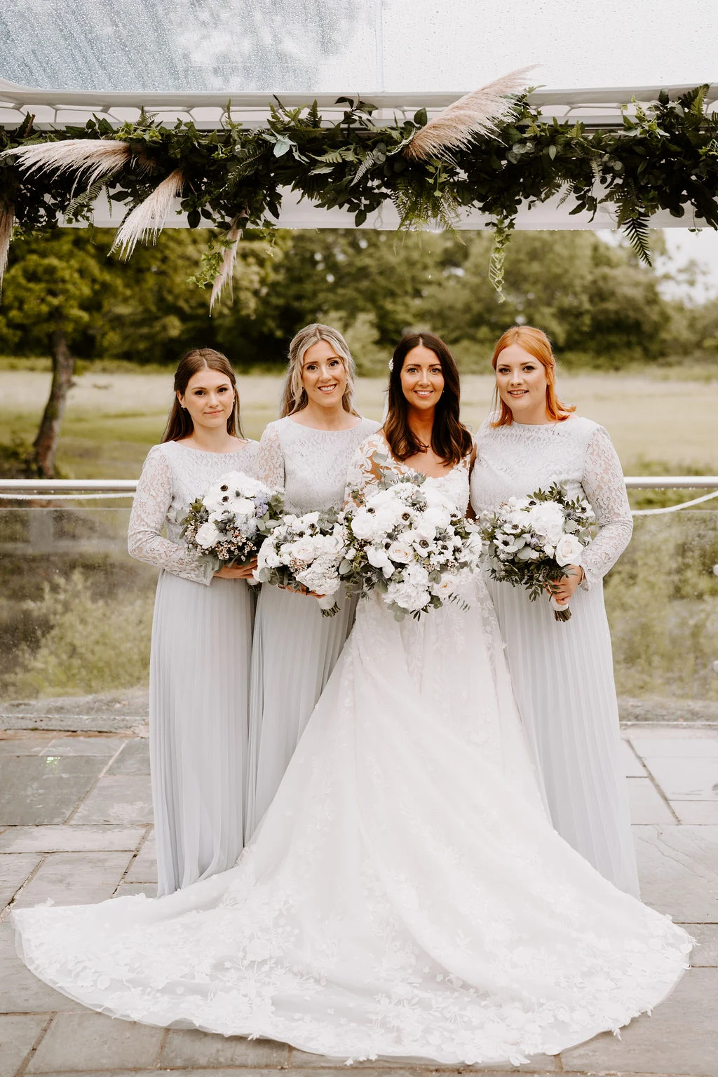 Jenny with her bridesmaids standing together outdoors