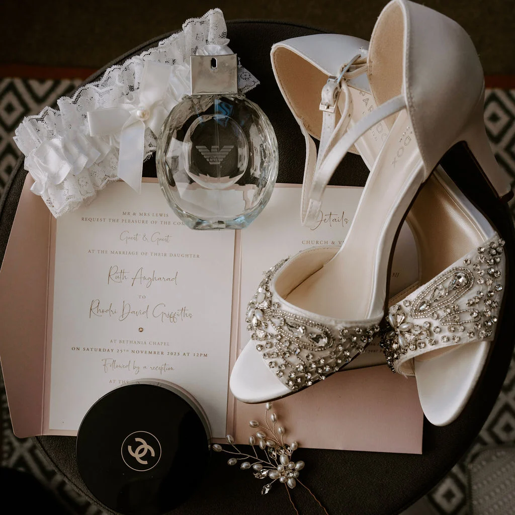Wedding shoes, rings and perfume arranged together during preparations