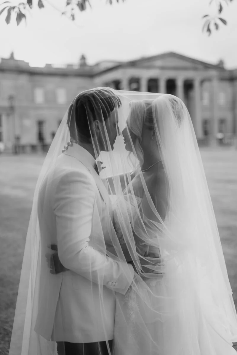 Newlyweds sharing a quiet moment beneath a veil