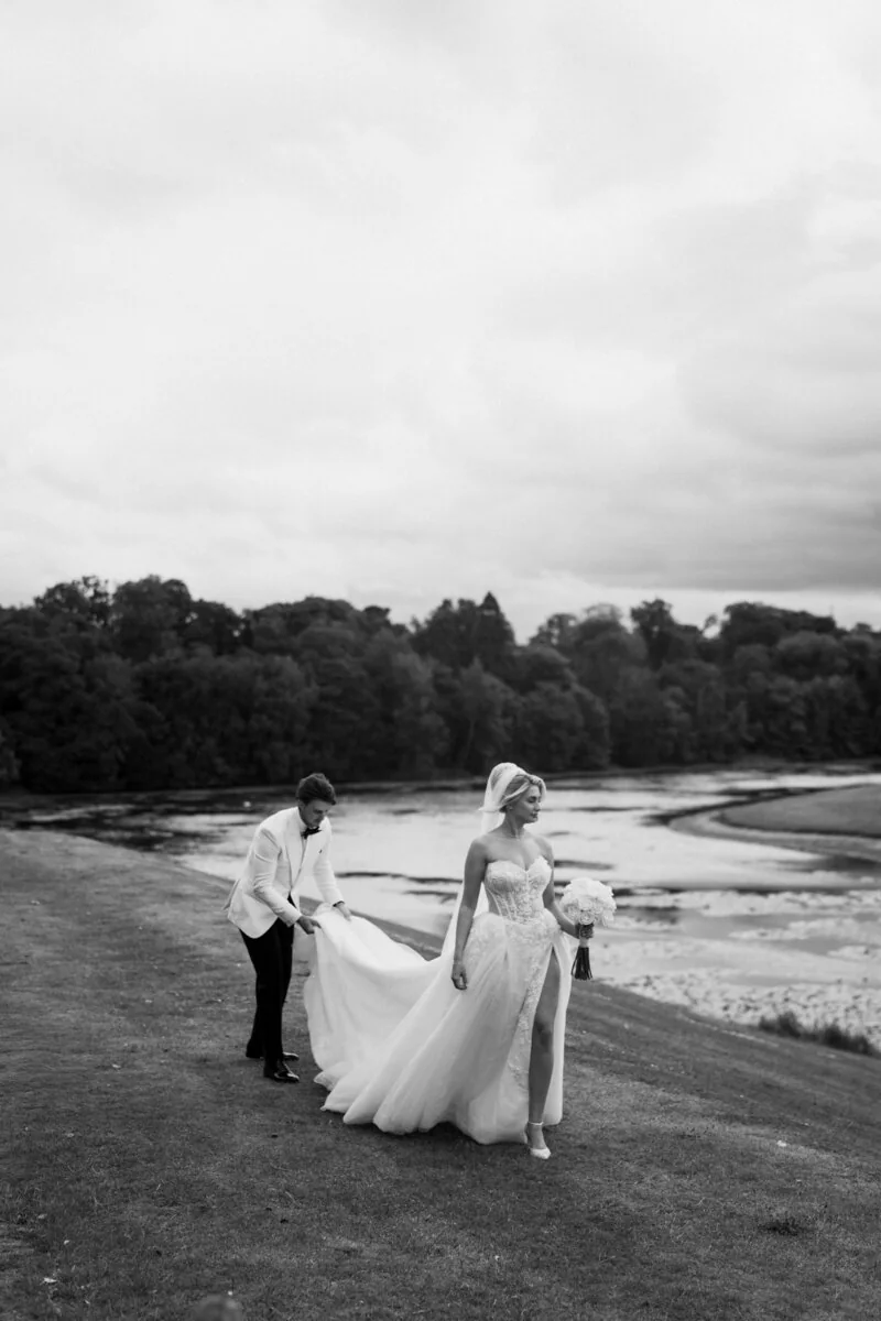 Black and white portrait of newlyweds beside a lake