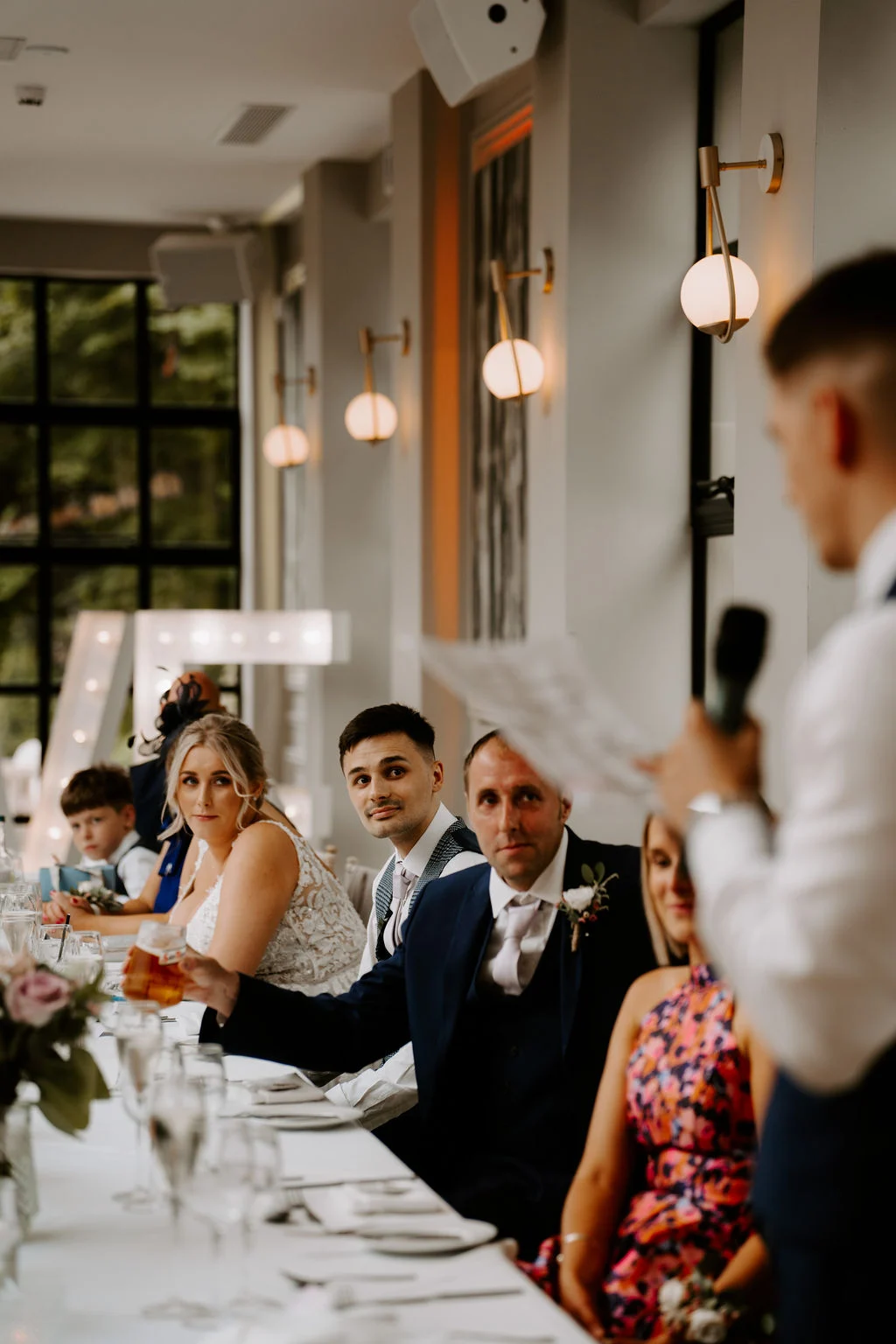 Analise and Mcauly listening to a speaker at their wedding reception at Woodlands Hotel