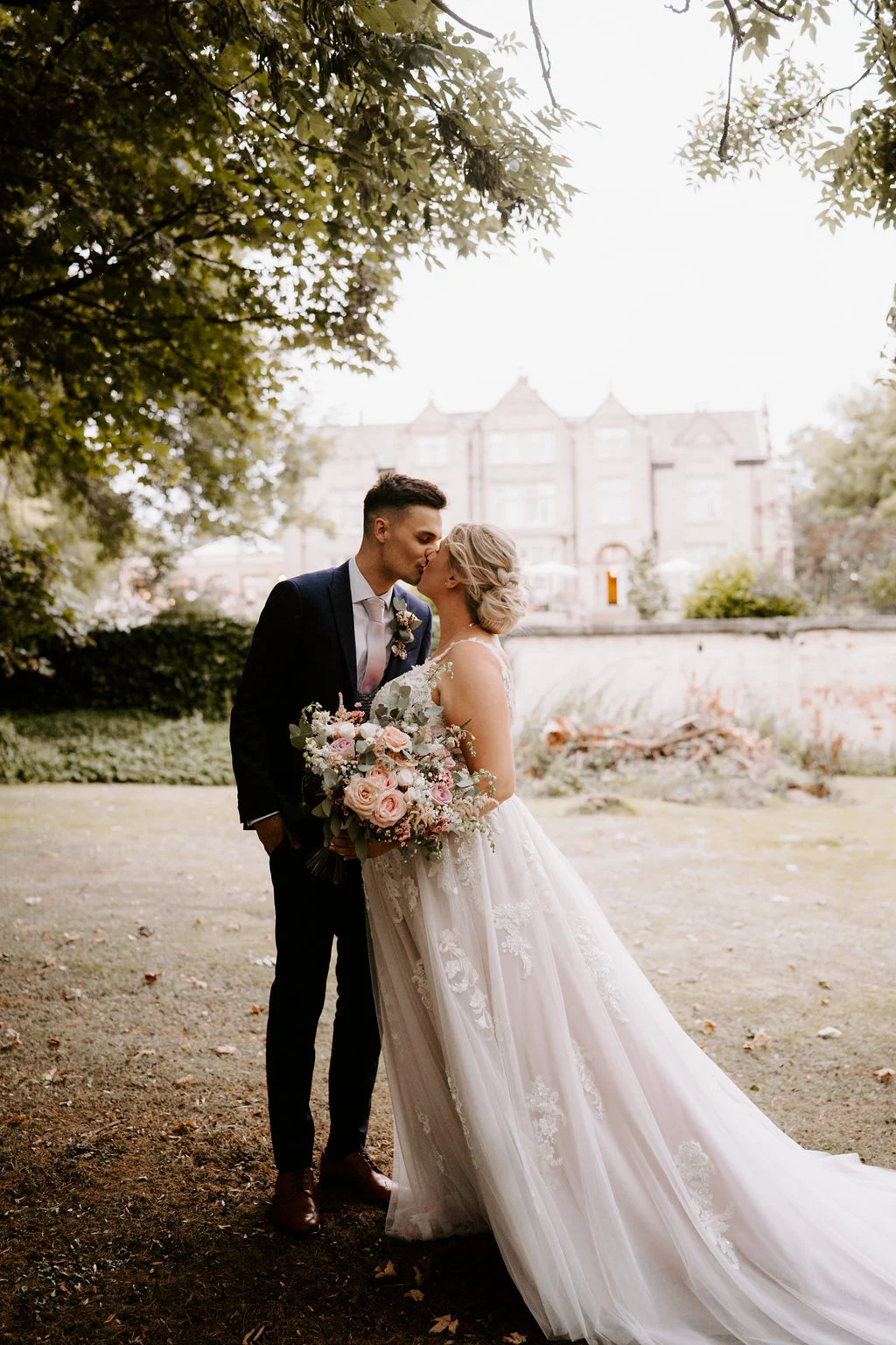 Analise and Mcauly kissing together beneath trees at Woodlands Hotel in Leeds