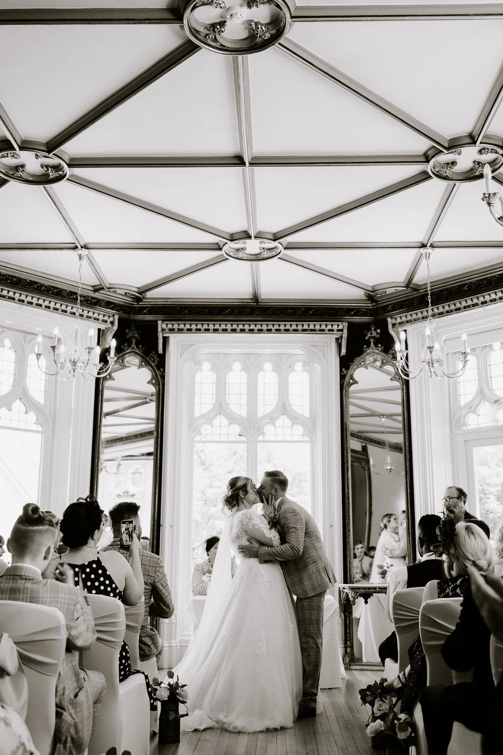 Black and white photograph of Jess and Matt embracing during their ceremony at Kenwood Hall