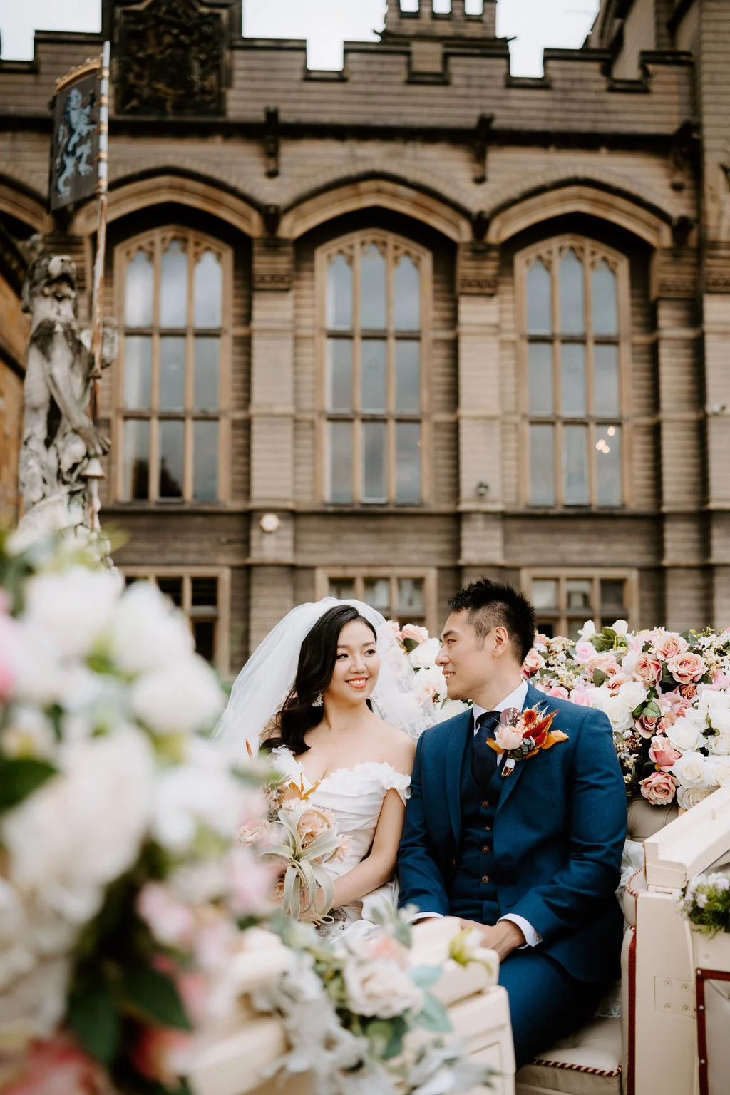 Yukki and Leslie laughing together outside Carlton Towers with flowers in the foreground