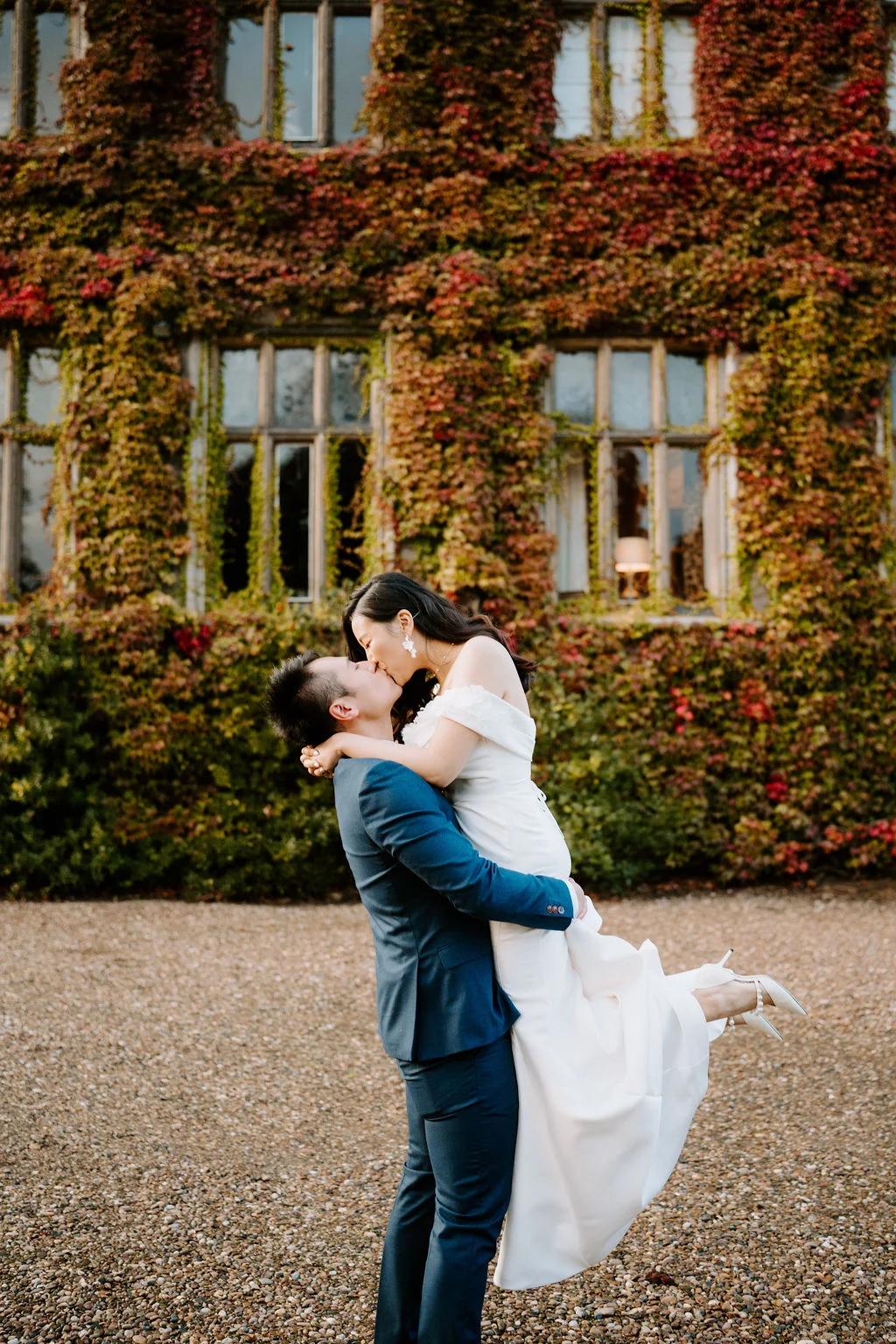 Leslie lifting Yukki outside an ivy-covered building at Carlton Towers
