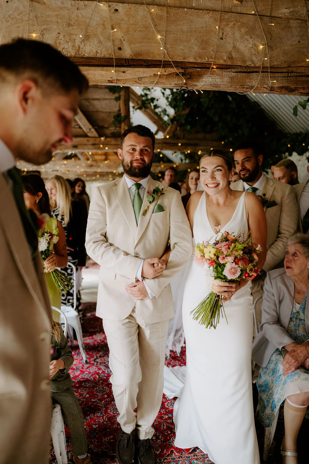 Bride and groom laughing together during afternoon drinks at Wilde Lodge