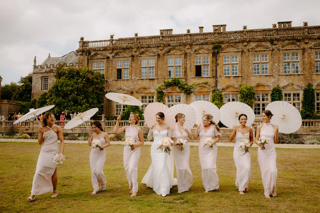 Katherine & Marcus walking along the tranquil lake and formal gardens at Brympton House in Yeovil at golden hour sunset