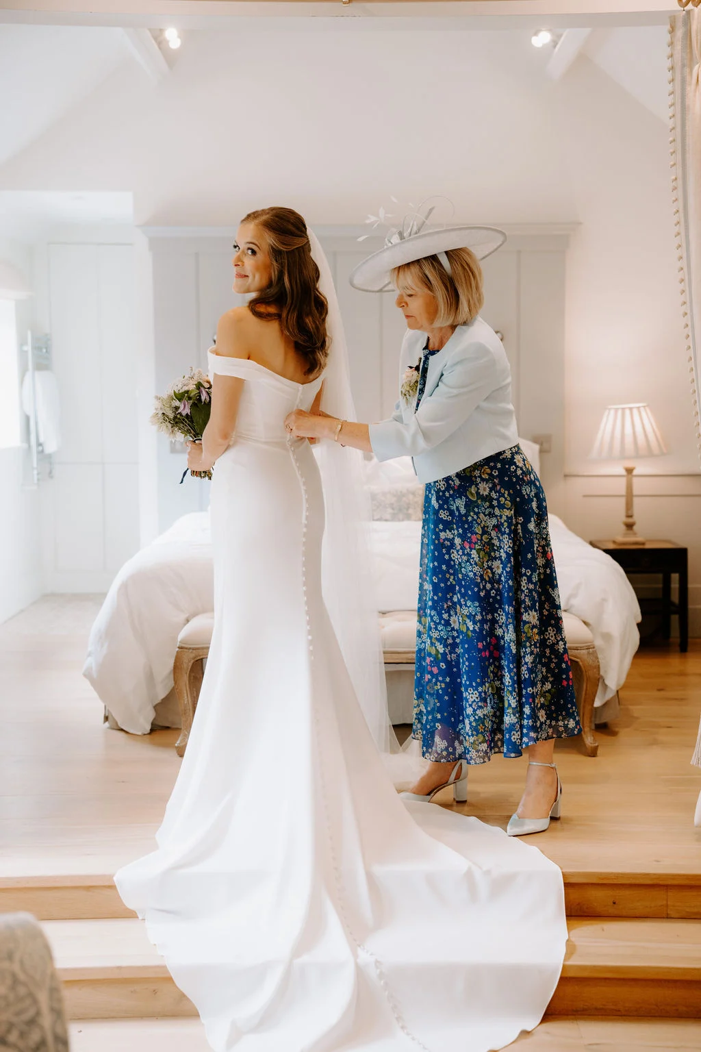 Hannah having her wedding dress adjusted in a bright preparation room