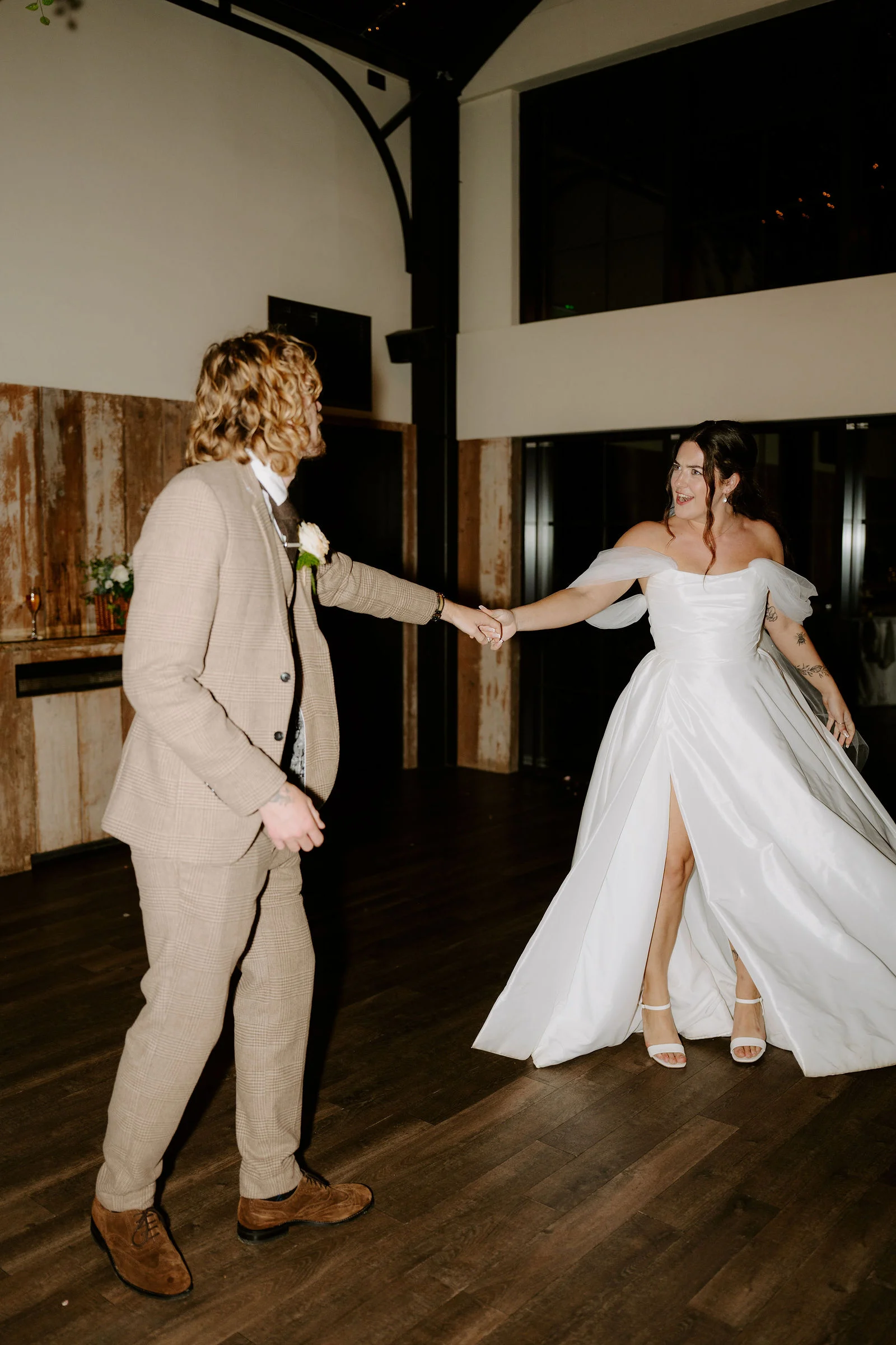 Jenny and Conan holding hands during their first dance at Foxtail Barns