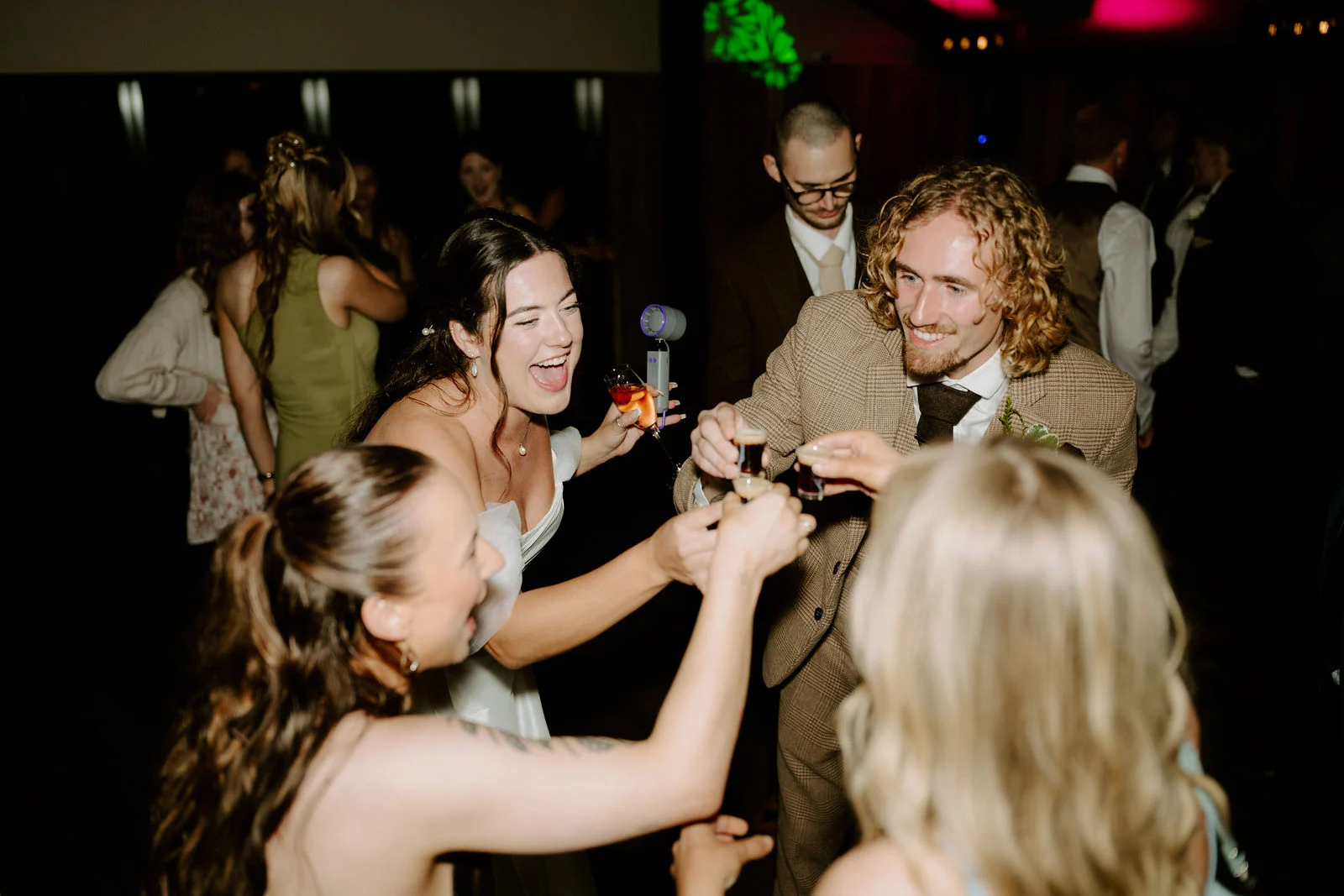 Jenny and Conan laughing with their guests on the dance floor at Foxtail Barns