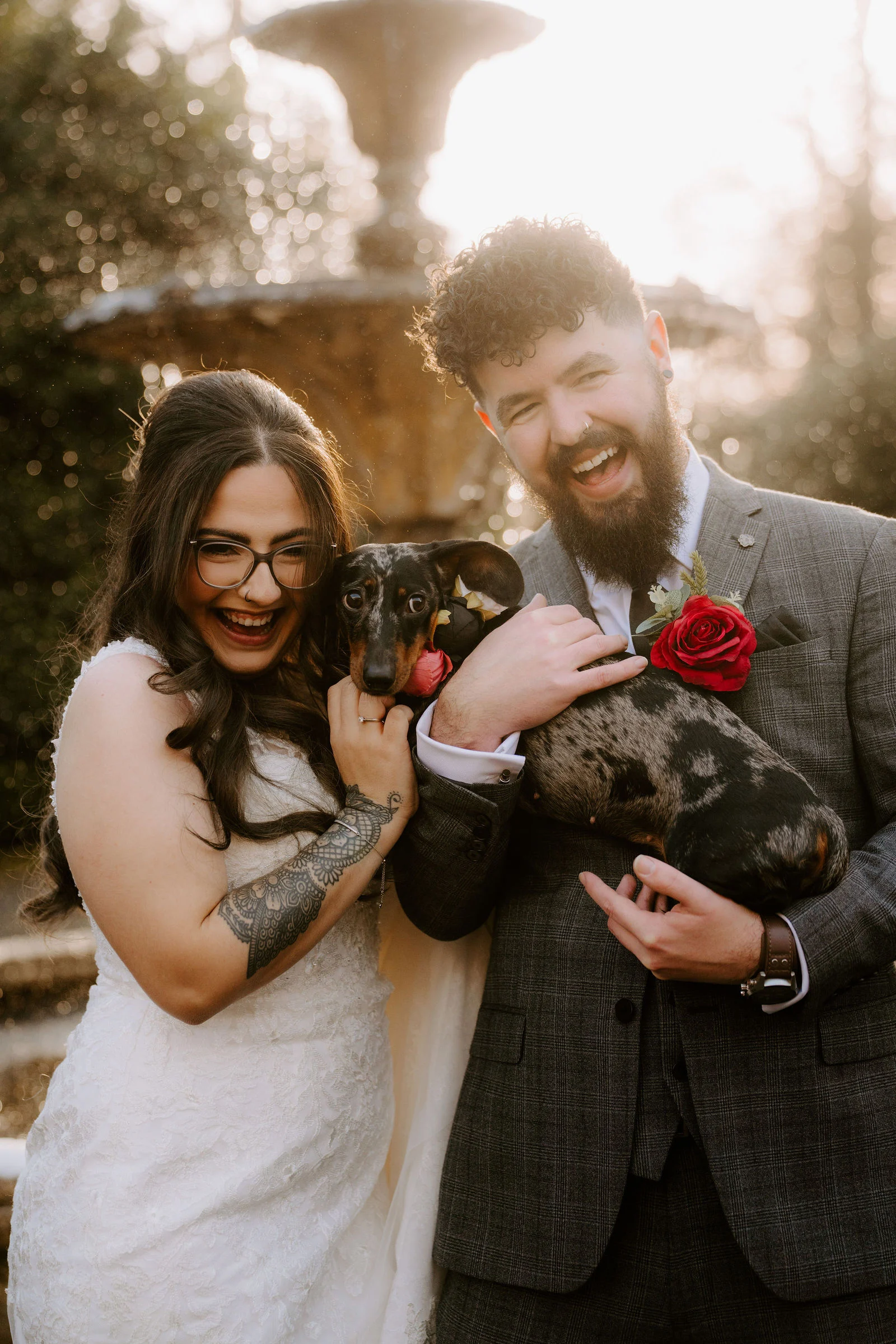 Farha and Alex holding a small dog in the grounds of Pendrell Hall
