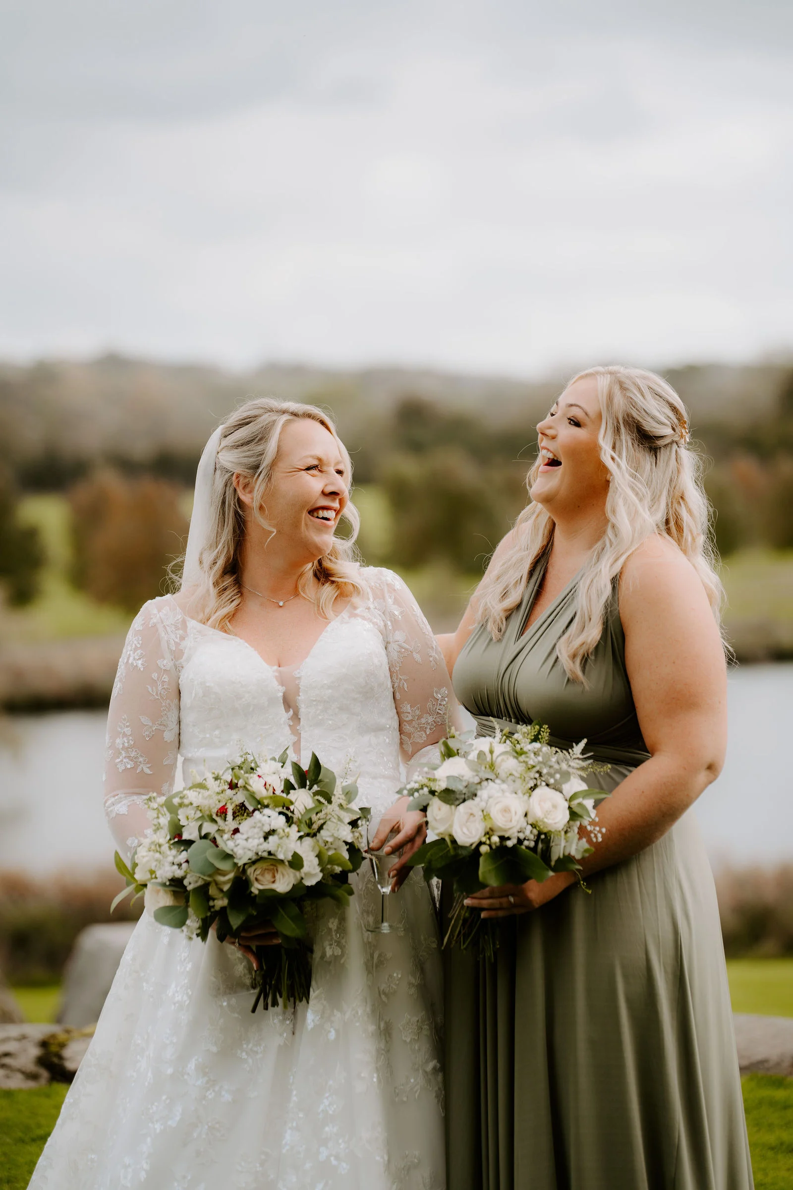 Jolene laughing with a member of her wedding party at The Ashes Barns
