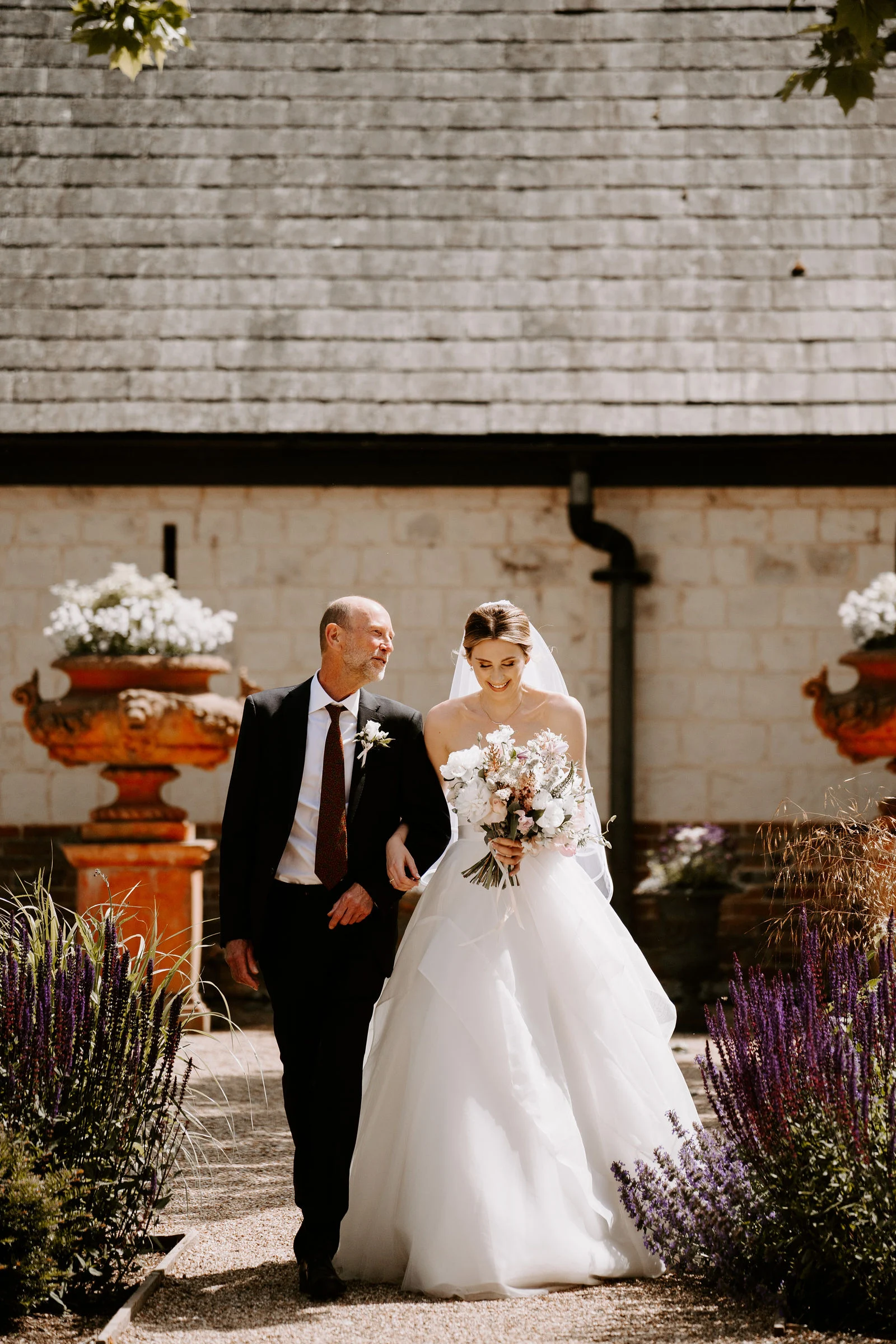 Andy and groomsmen putting on buttonholes before the ceremony at The Barn at Bury Court