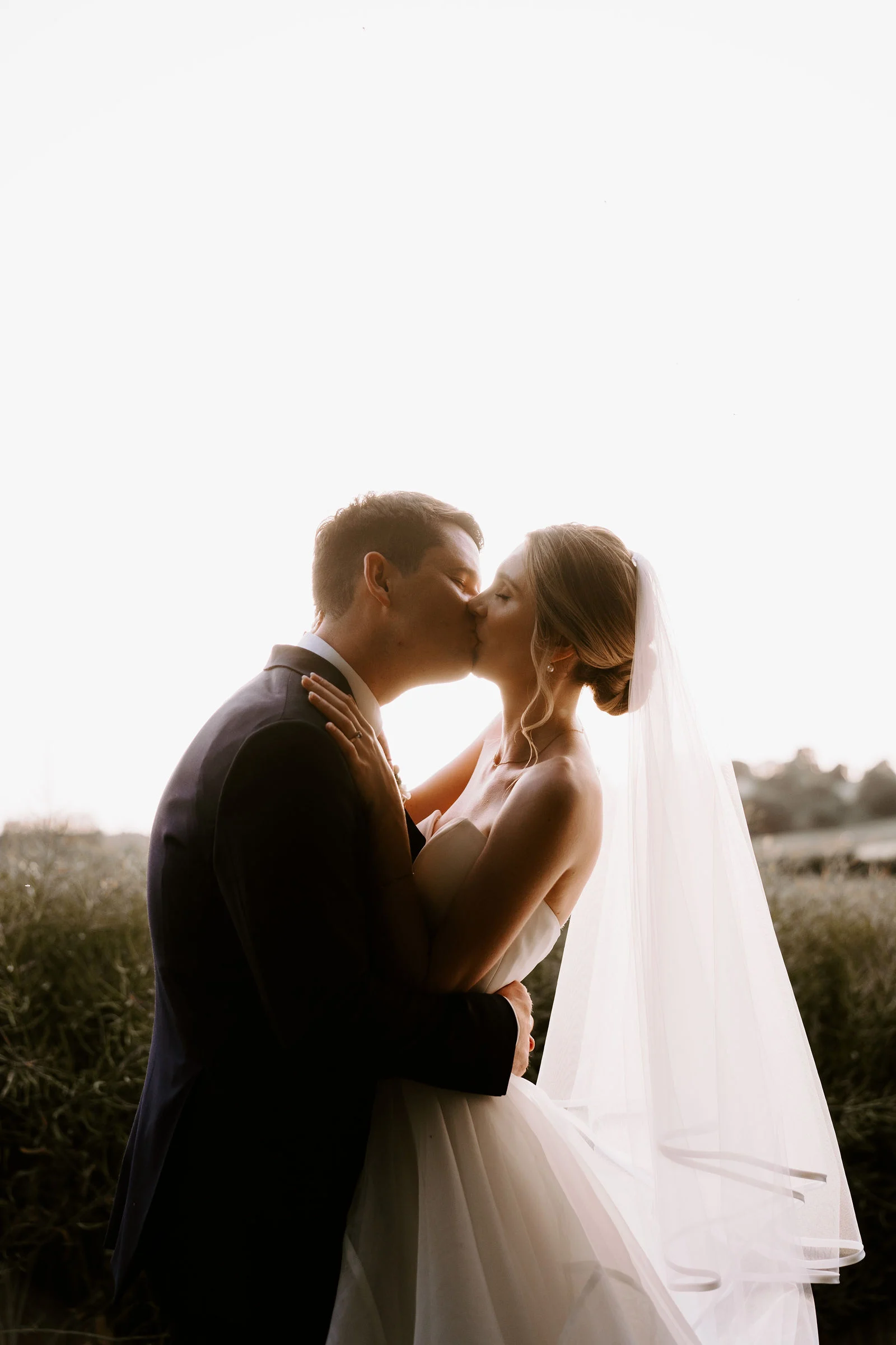 Andy and Jess smiling together on the stone garden path at Bury Court