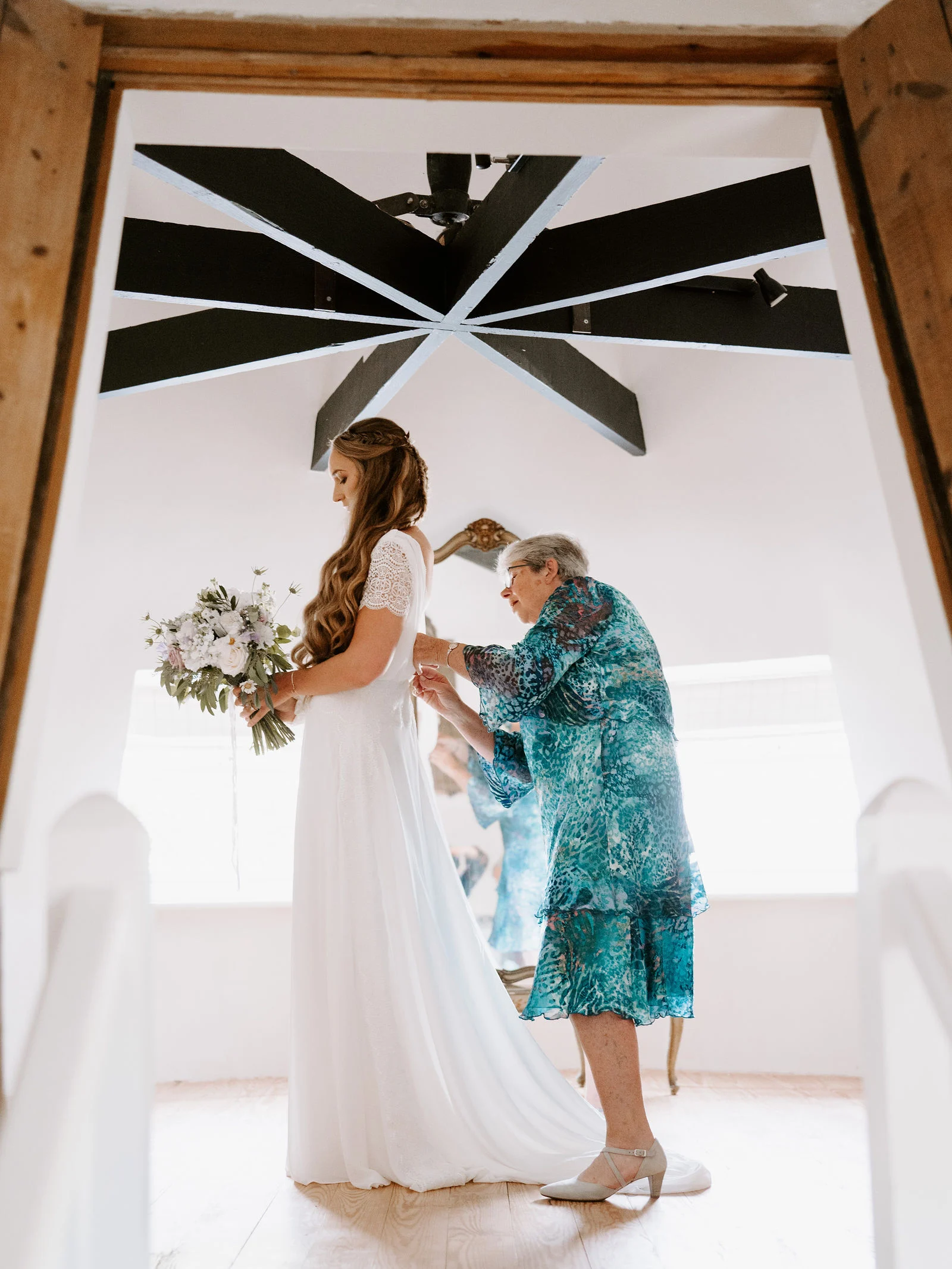 Sarah in her wedding gown during morning preparations in the Oast House bridal suite at The Barn at Bury Court