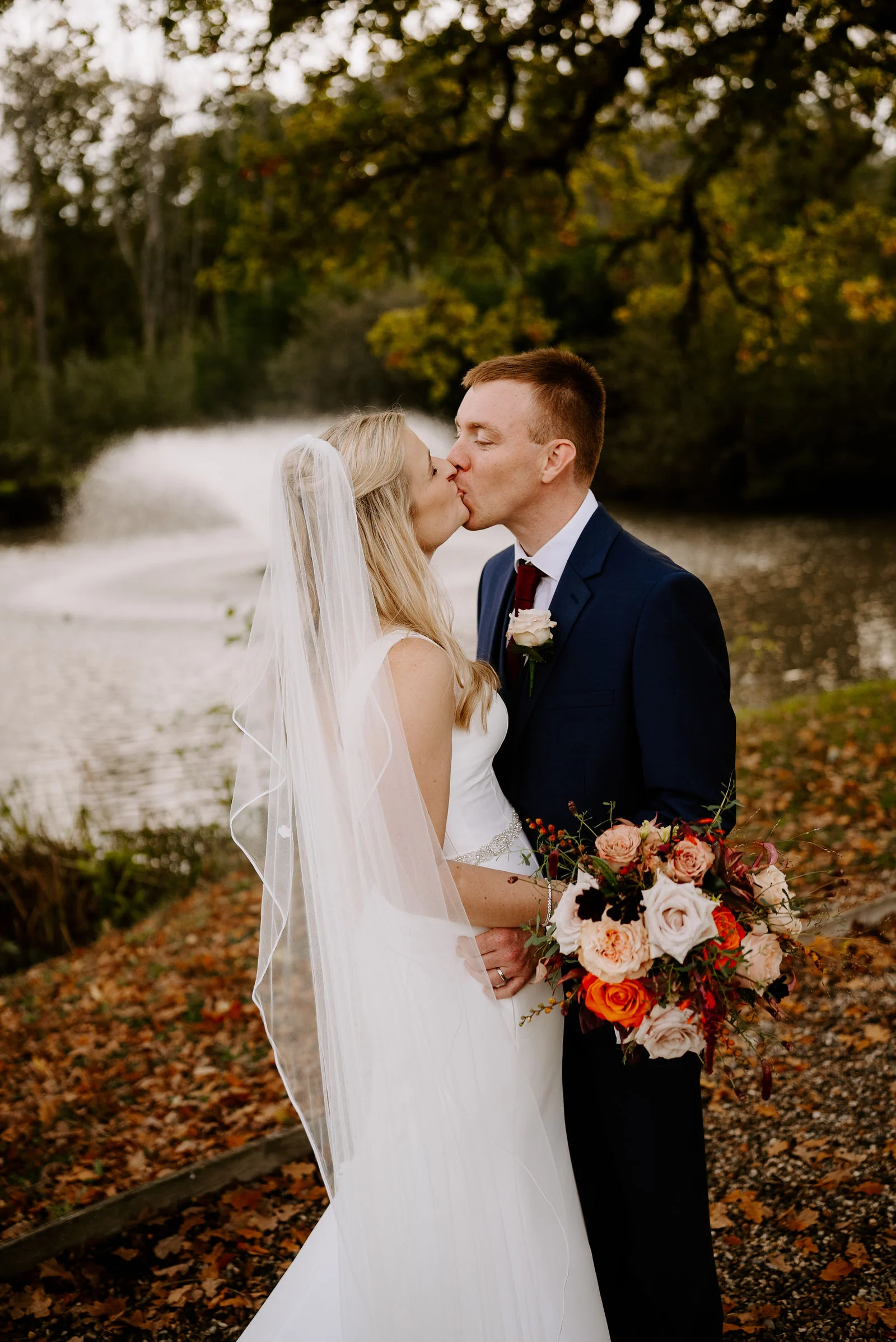 Romantic twilight portrait of Georgie and Alastair illuminated by fairy lights outside the Tudor manor at Lythe Hill