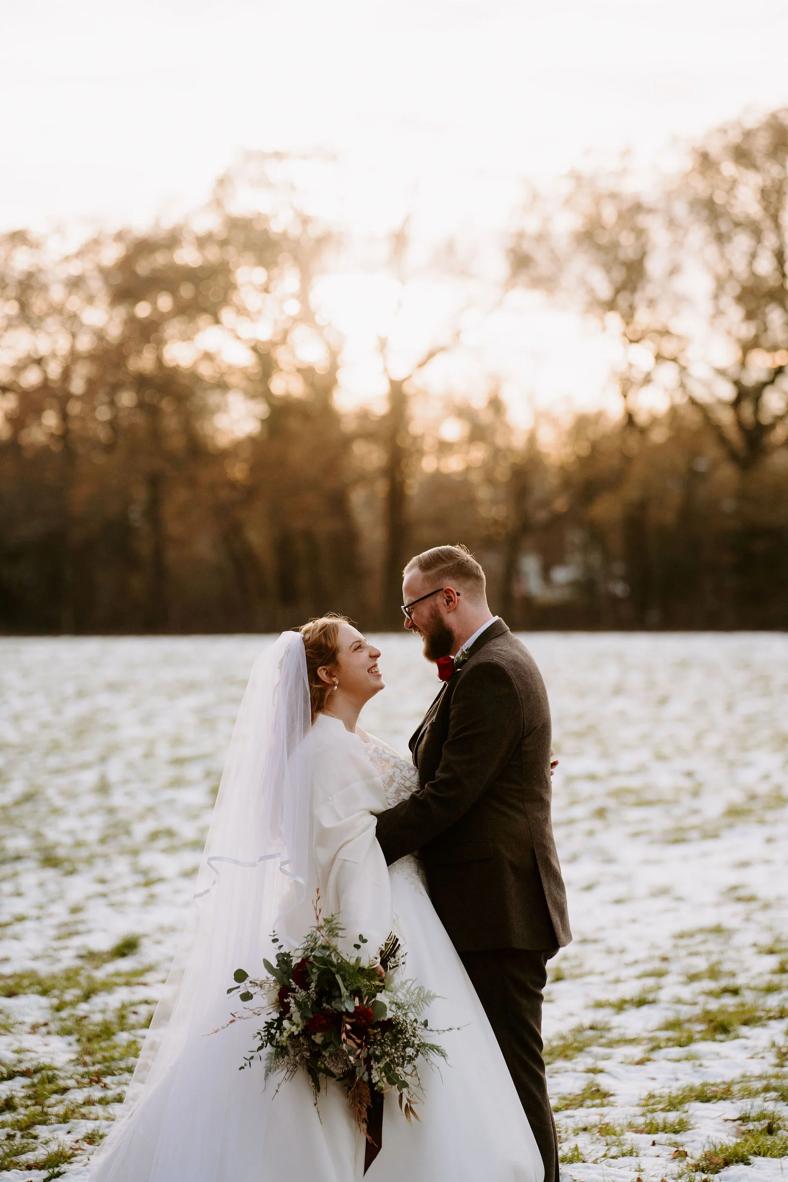 Jonathan and Tiffany standing inside the rustic timber interior of The Green Barn in Dorking, Surrey