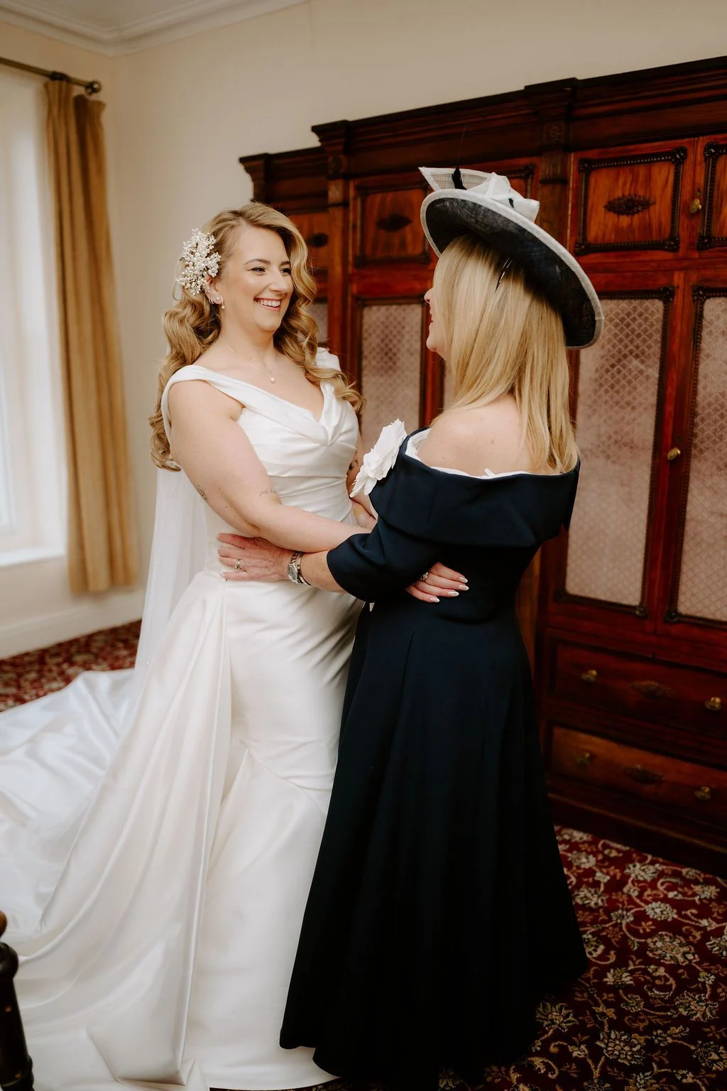 Sophie smiling with a guest during preparations in a wood-panelled room