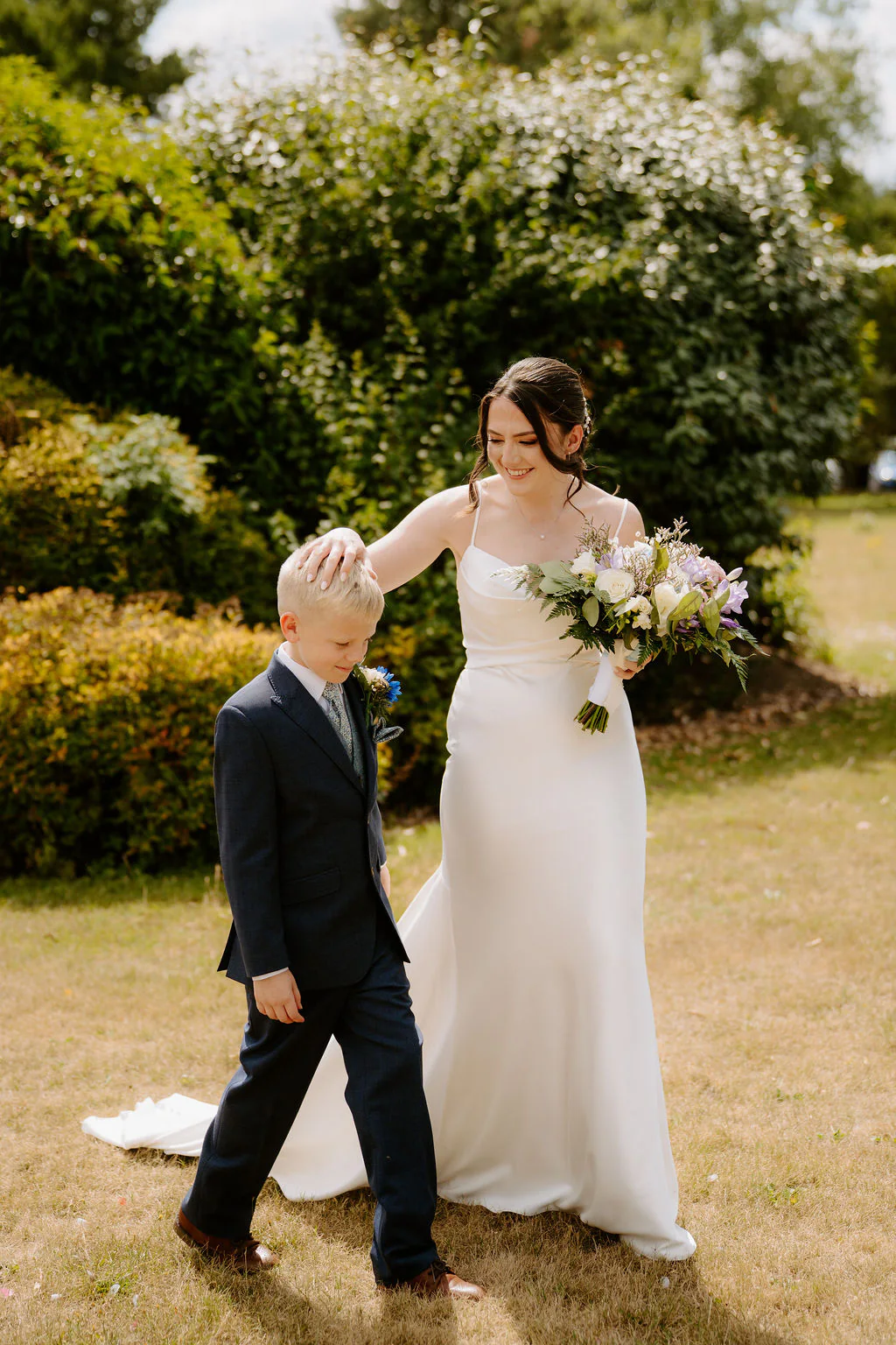 Alison & Kieran walking hand-in-hand through the lakeside gardens at Draycote Hotel