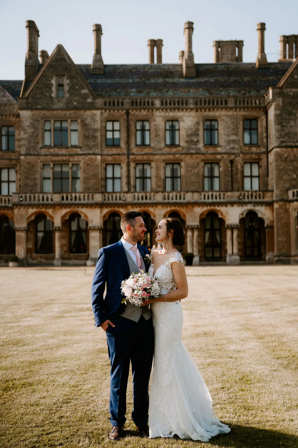 Kate & Josh romantic couple portrait in front of the 16th-century chapel at Walton Hall in Wellesbourne