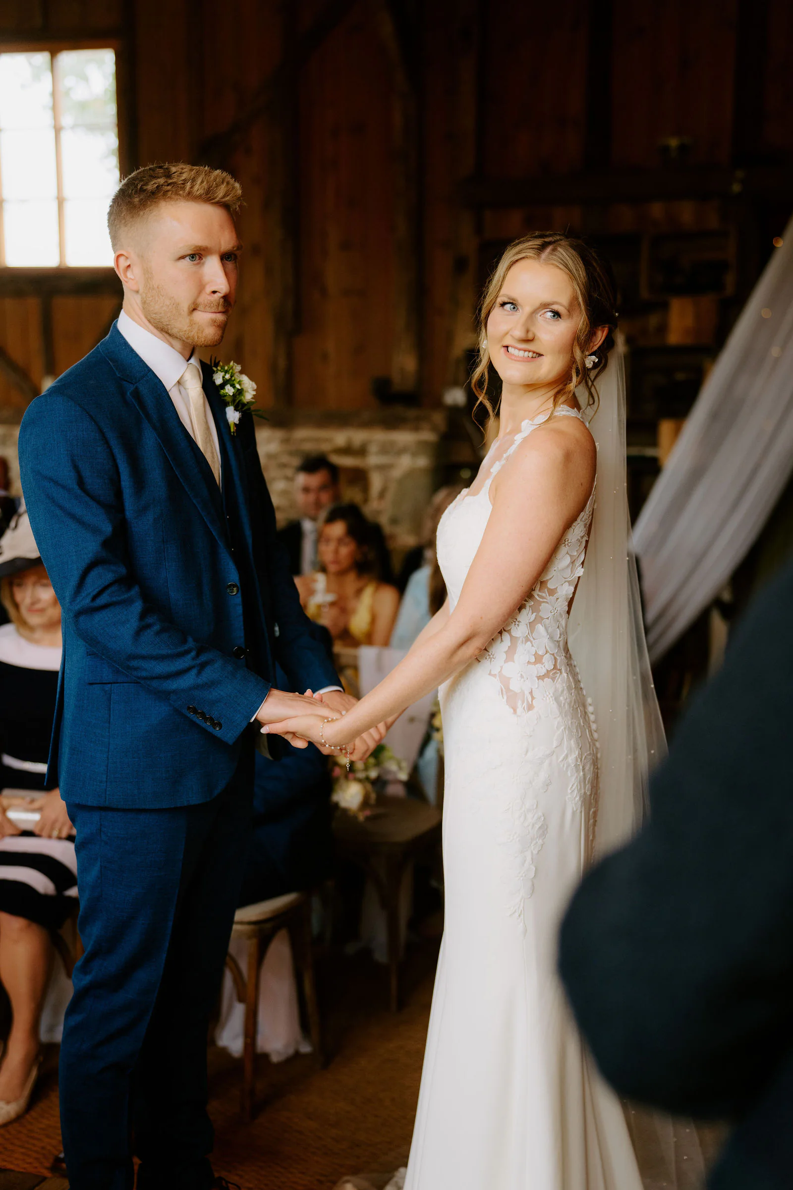 Vanessa and Harvey laughing joyfully as confetti showers over them outside Bowerchalke Barn