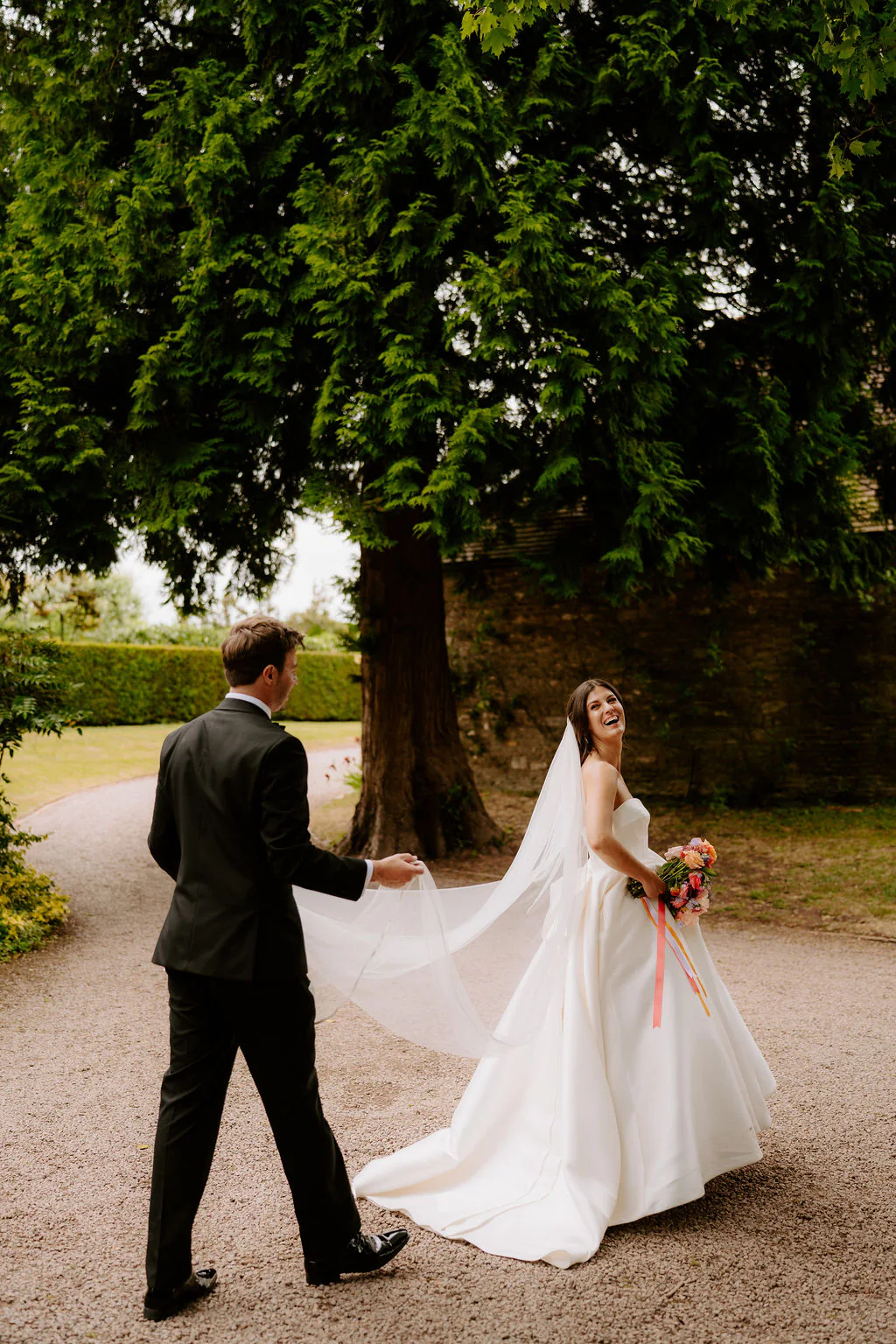 Confetti walk across the stone bridge over the medieval moat at Birtsmorton Court