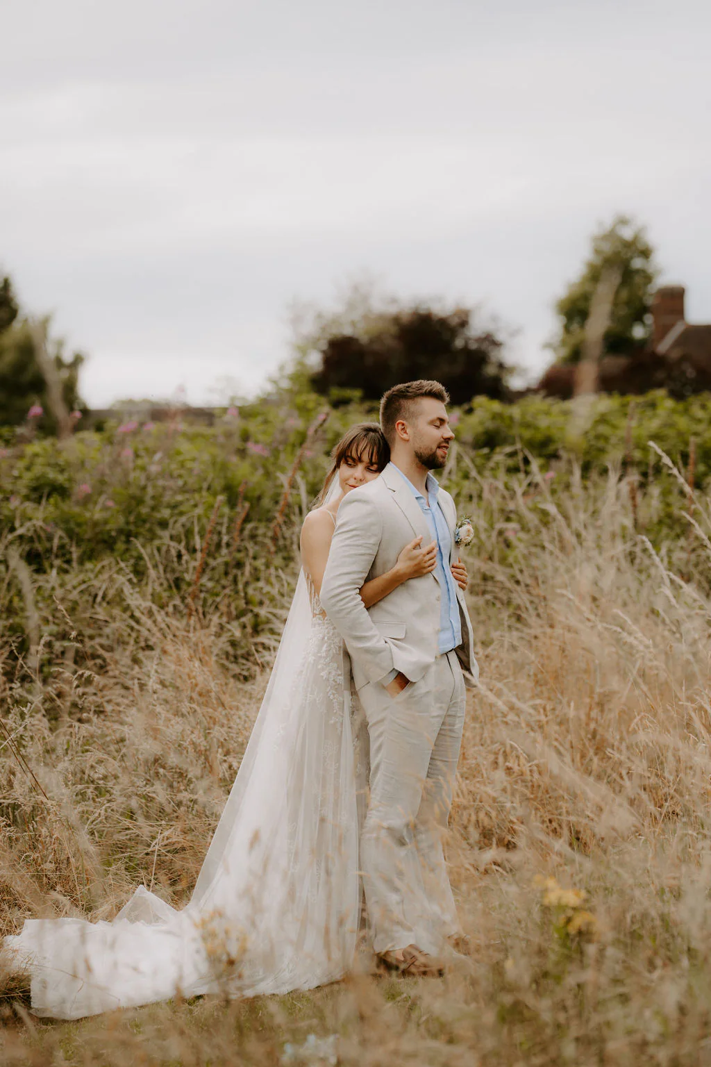 Liz and Jack embracing among tall grasses at Hogarths Stone Manor